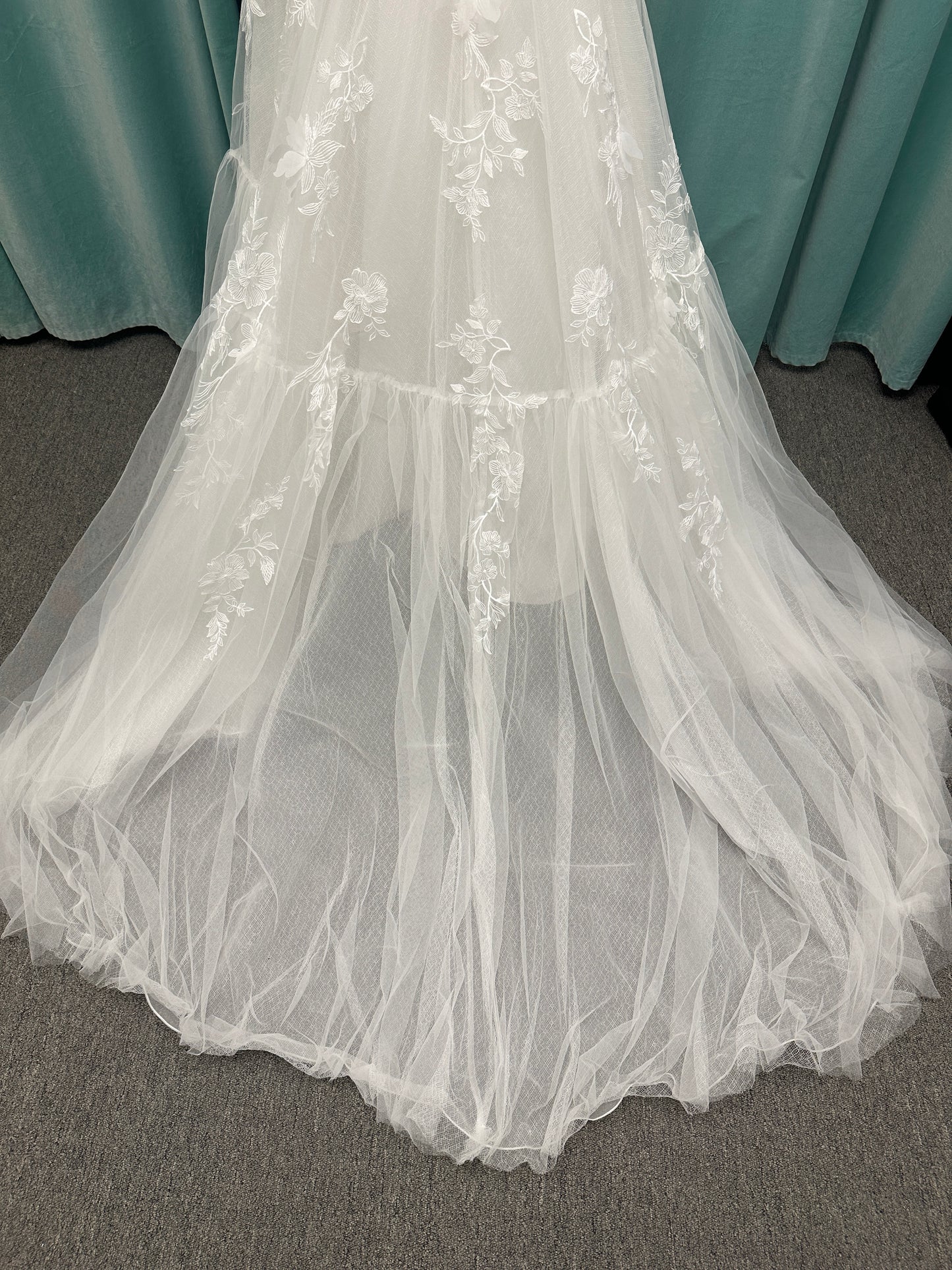 Stella York SY8153 ballgown featuring 3D lace spaghetti strap bodice with sheer V-neckline and layered tulle skirt with floral appliqués