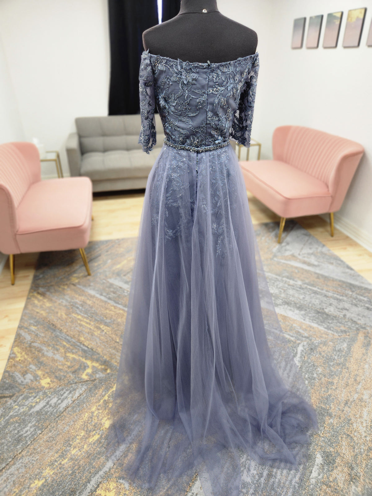 Morilee MGNY 72834 off-the-shoulder mother of the bride gown with embroidered lace bodice, sheer sleeves, and flowing A-line skirt with detachable overskirt.