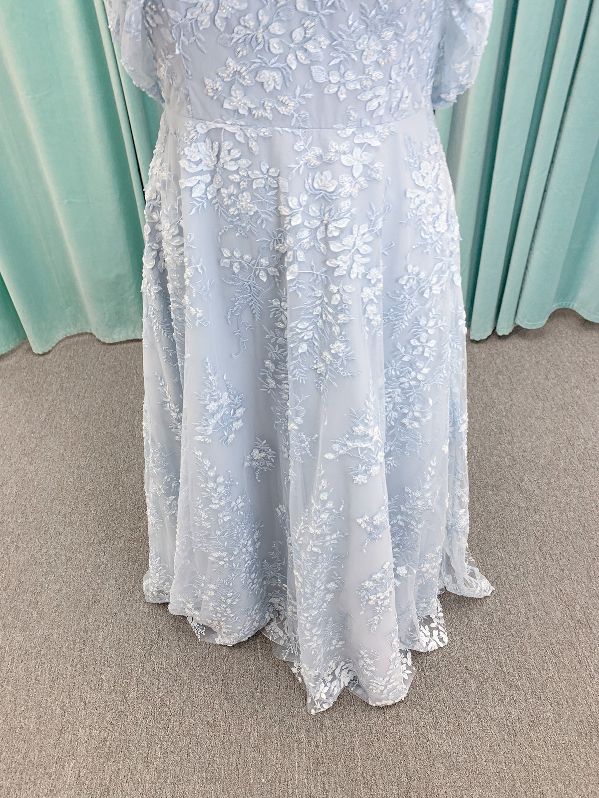 Morilee MLNY 73101 A-line mother of the bride dress on mannequin with strapless sweetheart neckline, detachable off-the-shoulder drape, 3D floral bodice, layered floral lace appliques, and full tulle skirt with pockets