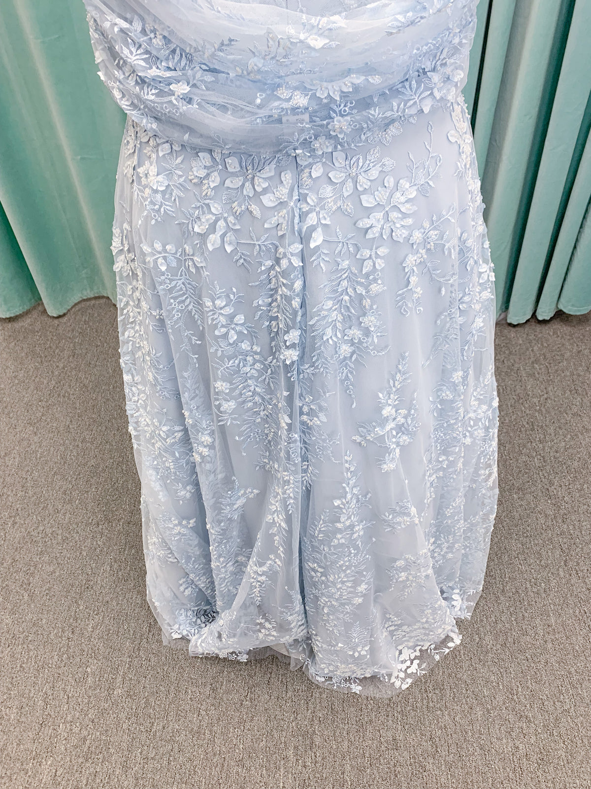 Morilee MLNY 73101 A-line mother of the bride dress on mannequin with strapless sweetheart neckline, detachable off-the-shoulder drape, 3D floral bodice, layered floral lace appliques, and full tulle skirt with pockets
