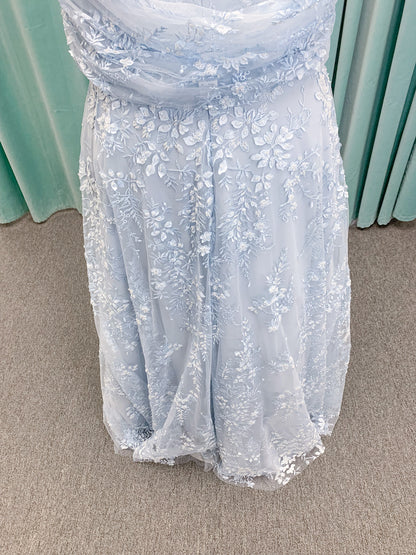 Morilee MLNY 73101 A-line mother of the bride dress on mannequin with strapless sweetheart neckline, detachable off-the-shoulder drape, 3D floral bodice, layered floral lace appliques, and full tulle skirt with pockets