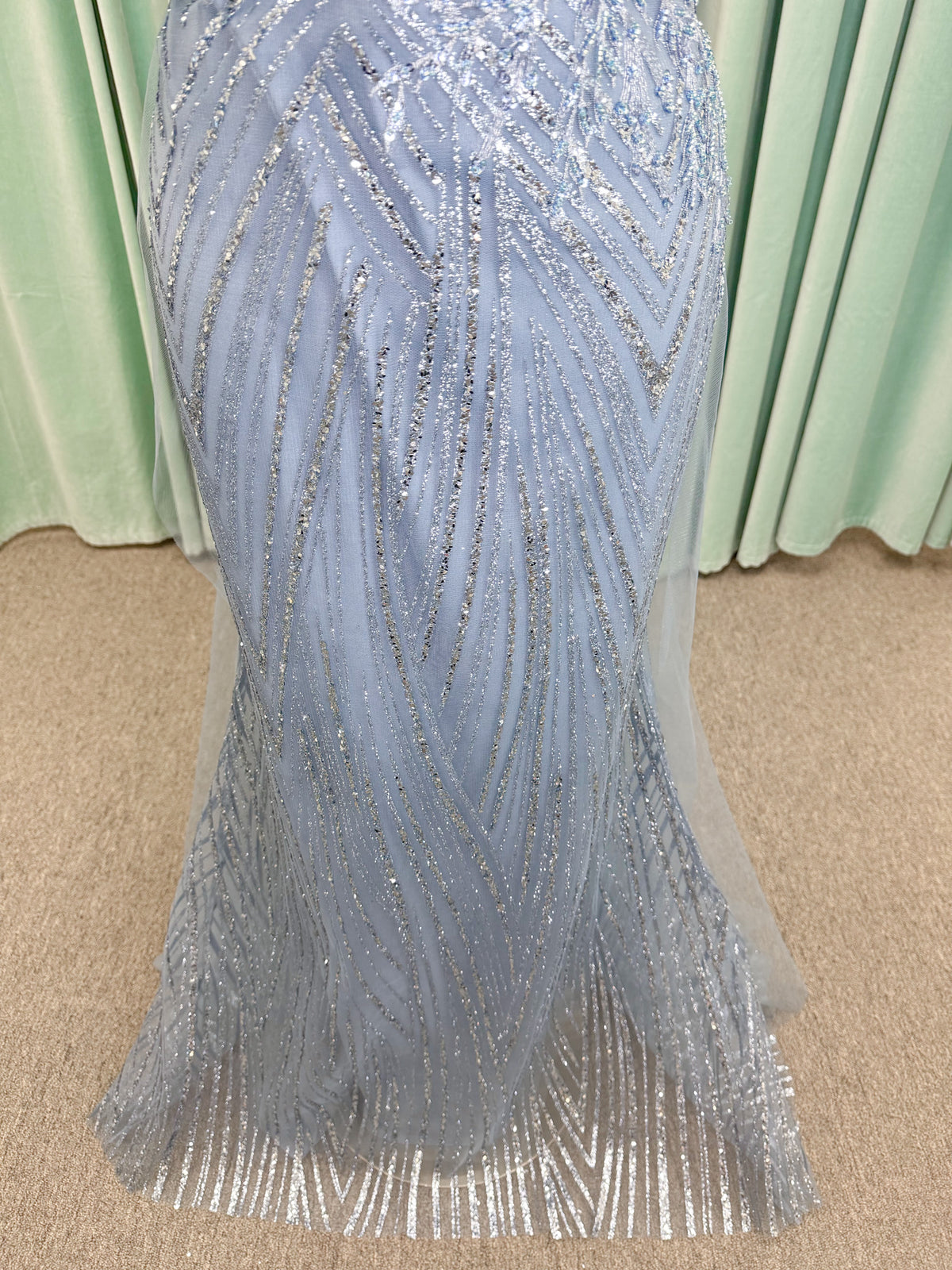 Morilee MLNY 73110 mermaid mother of the bride dress on mannequin with off-the-shoulder sweetheart neckline with foldover cuff, sequin-beaded net bodice, sheer tulle back panel, and sweep train