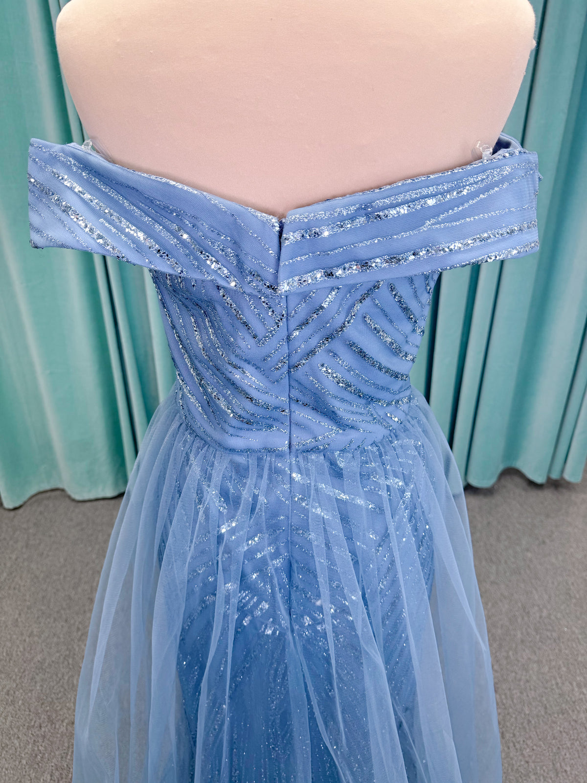 Morilee MLNY 73110 mermaid mother of the bride dress on mannequin with off-the-shoulder sweetheart neckline with foldover cuff, sequin-beaded net bodice, sheer tulle back panel, and sweep train