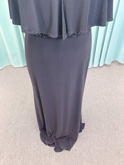 Morilee MLNY 73124 sheath mother of the bride dress on mannequin with V-neckline, flowing capelet overlay, crystal beaded waistband, and slim jersey sheath skirt