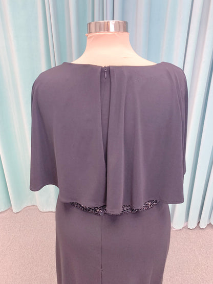 Morilee MLNY 73124 sheath mother of the bride dress on mannequin with V-neckline, flowing capelet overlay, crystal beaded waistband, and slim jersey sheath skirt