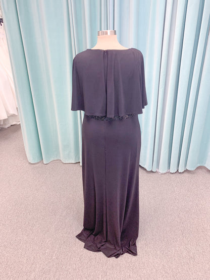 Morilee MLNY 73124 sheath mother of the bride dress on mannequin with V-neckline, flowing capelet overlay, crystal beaded waistband, and slim jersey sheath skirt