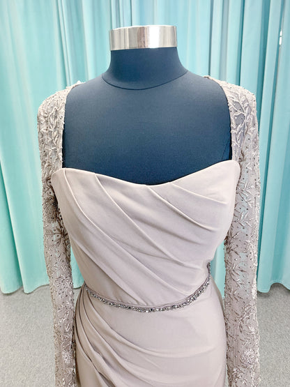Morilee MLNY 73160 sheath mother of the bride dress on mannequin with modified sweetheart neckline, draped crepe bodice, sheer illusion long sleeves with lace applique, detachable beaded belt, and keyhole back