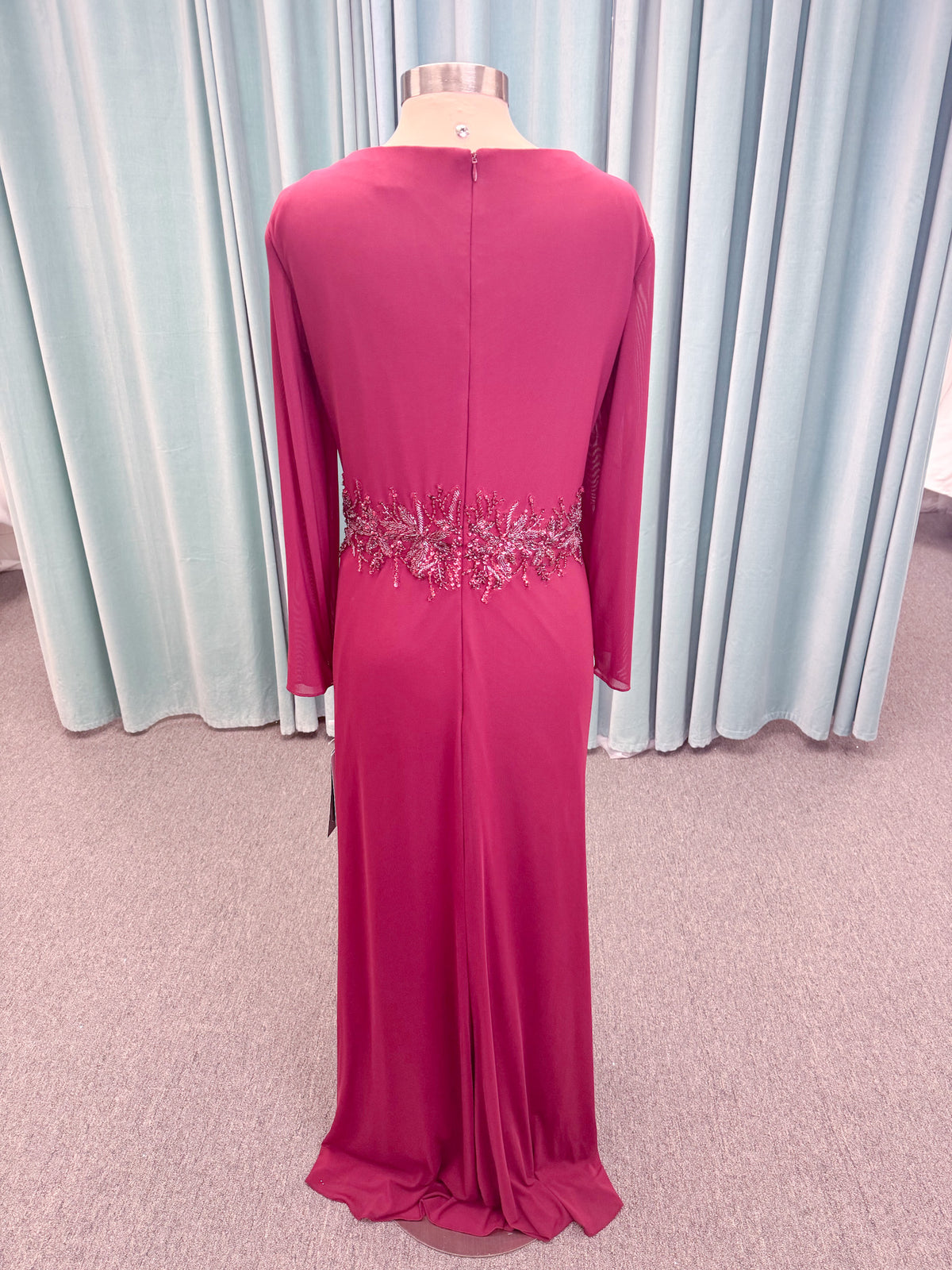 Morilee MLNY 73175 fit and flare mother of the bride dress on mannequin with draped V-neckline, long sleeves, beaded appliques, beaded waist, and slit skirt
