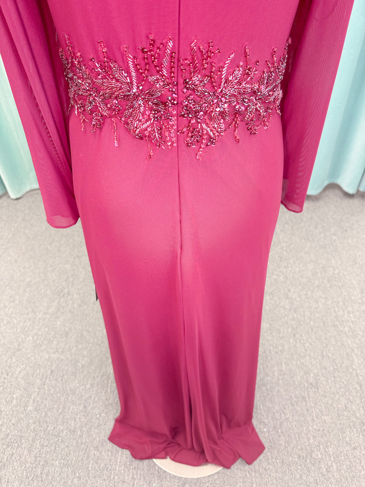 Morilee MLNY 73175 fit and flare mother of the bride dress on mannequin with draped V-neckline, long sleeves, beaded appliques, beaded waist, and slit skirt