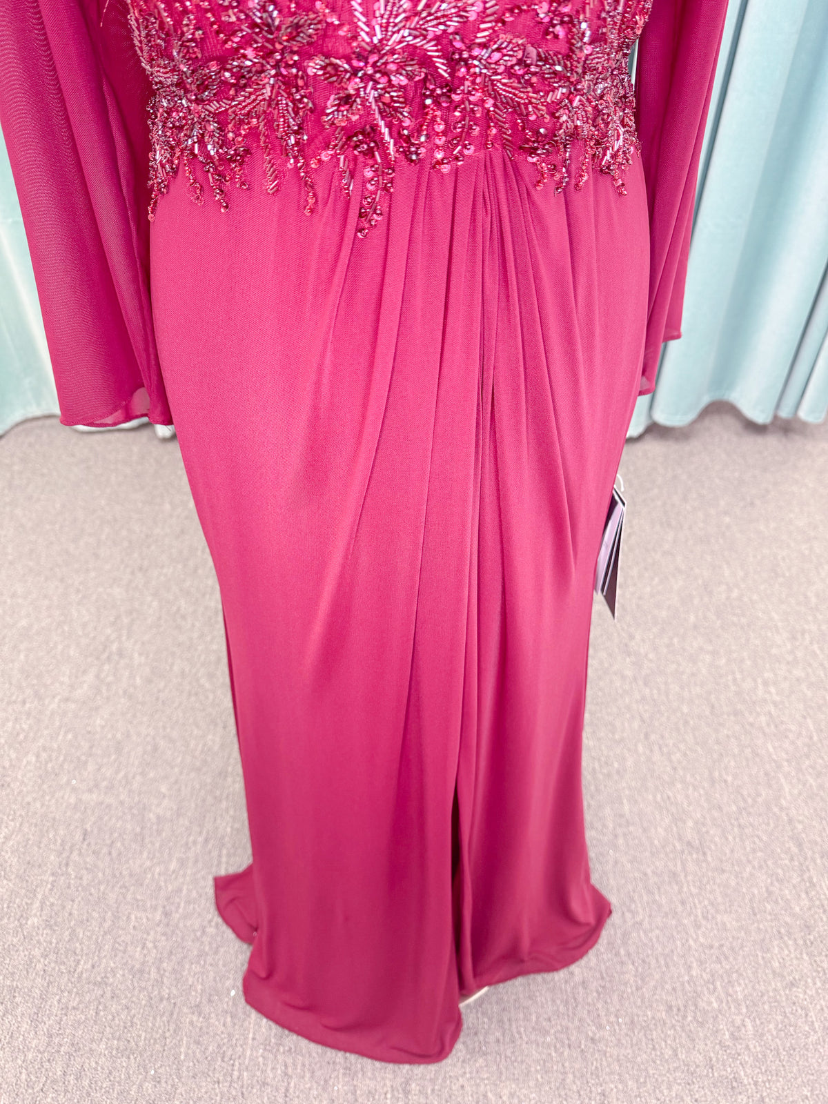 Morilee MLNY 73175 fit and flare mother of the bride dress on mannequin with draped V-neckline, long sleeves, beaded appliques, beaded waist, and slit skirt