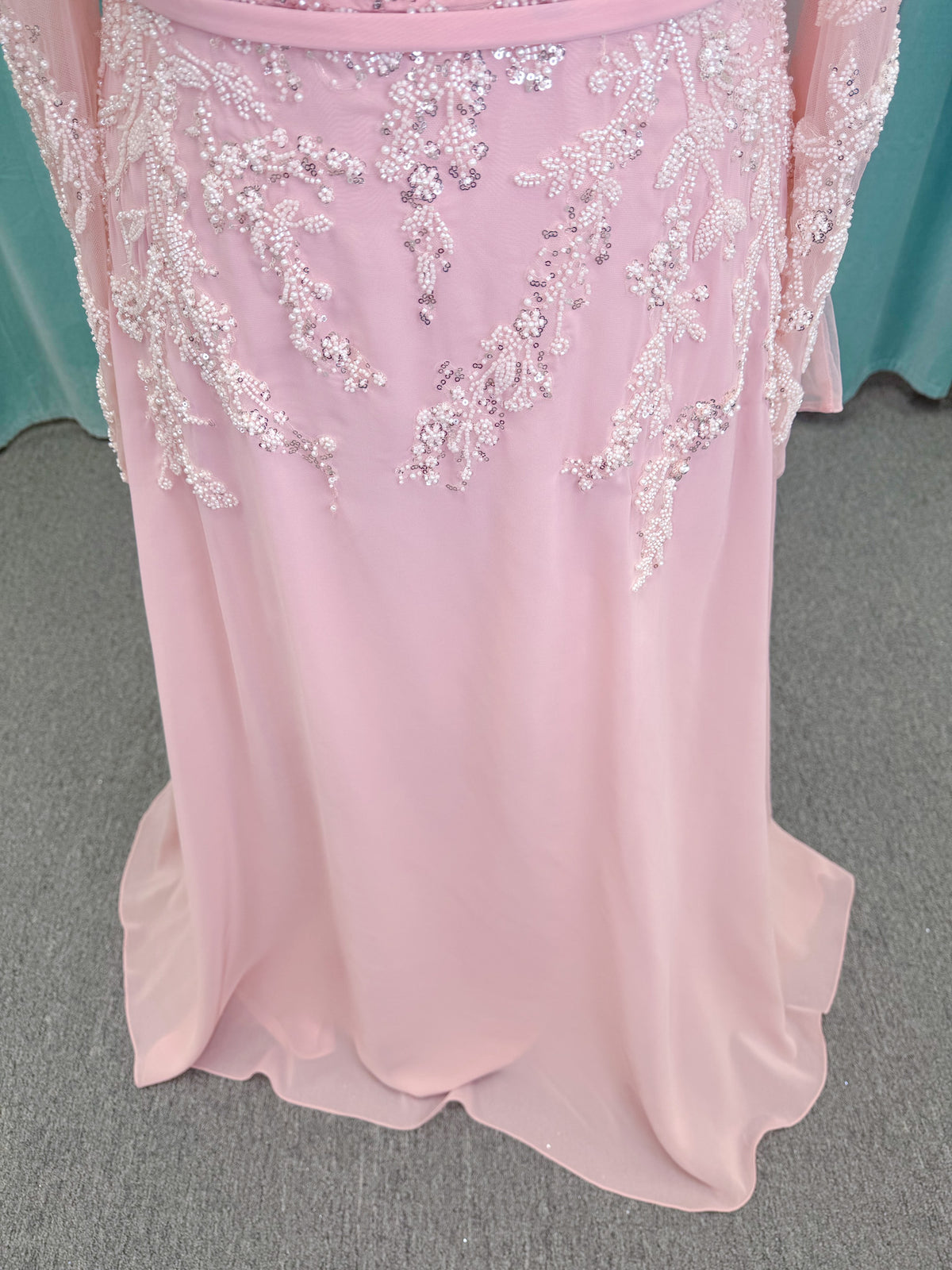  Morilee MLNY 73185 plus size A-line mother of the bride dress on mannequin with square neckline, draped chiffon bodice, sheer illusion long sleeves, beaded appliques, detachable self-belt, and flowing A-line skirt