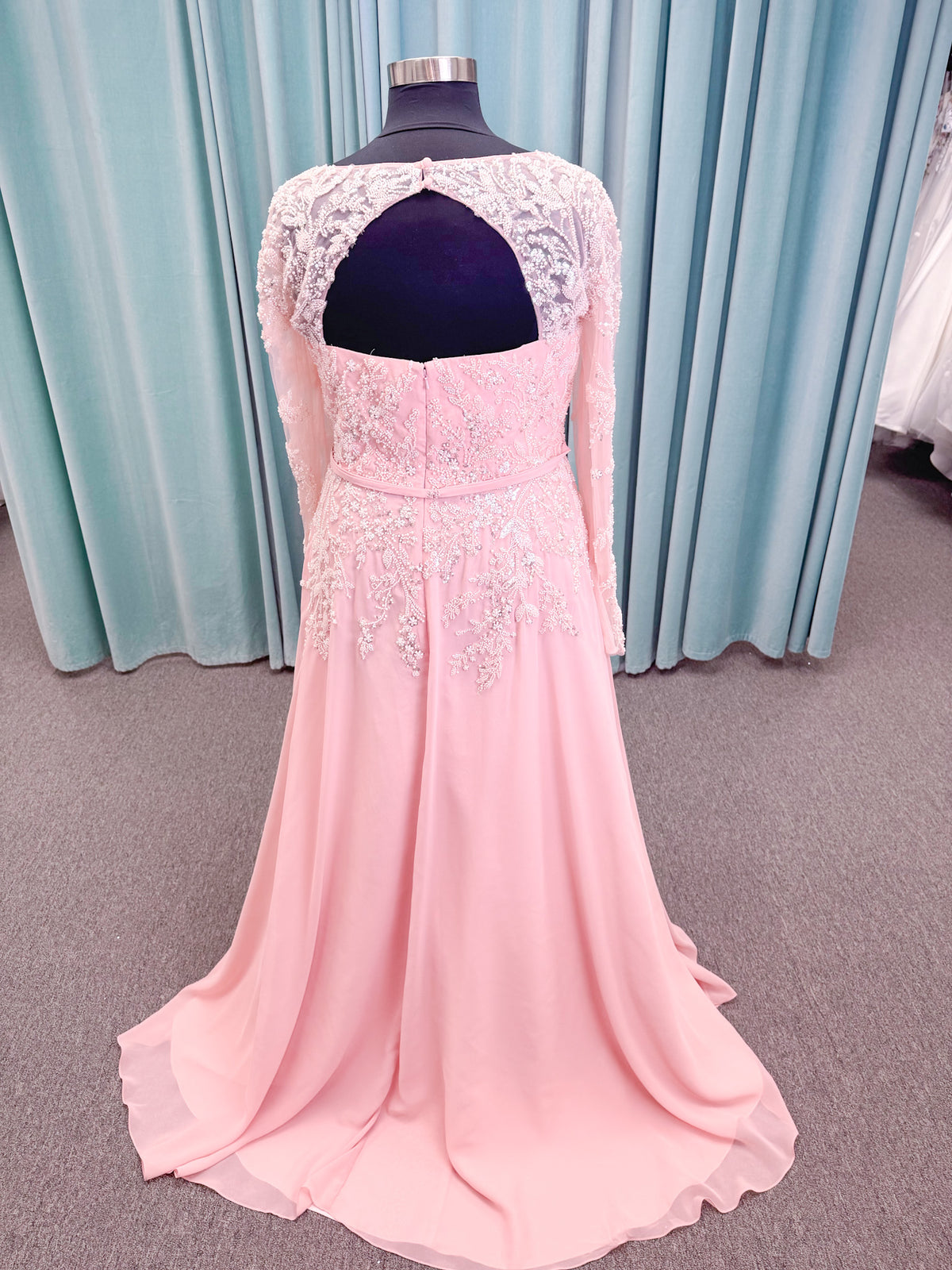  Morilee MLNY 73185 plus size A-line mother of the bride dress on mannequin with square neckline, draped chiffon bodice, sheer illusion long sleeves, beaded appliques, detachable self-belt, and flowing A-line skirt