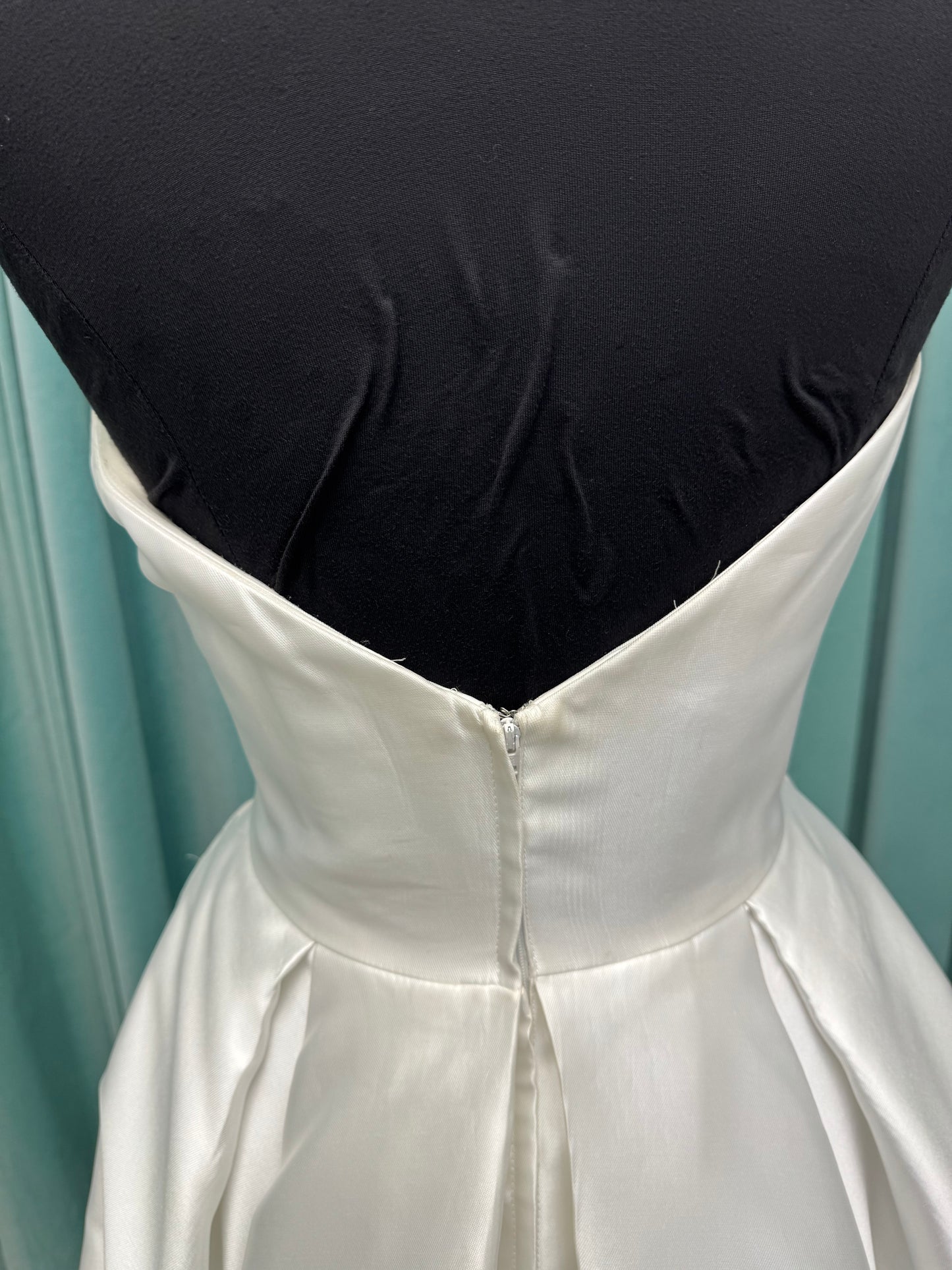 Achelios ivory strapless sweetheart satin ballgown wedding dress on mannequin with full skirt and clean structured bodice.
