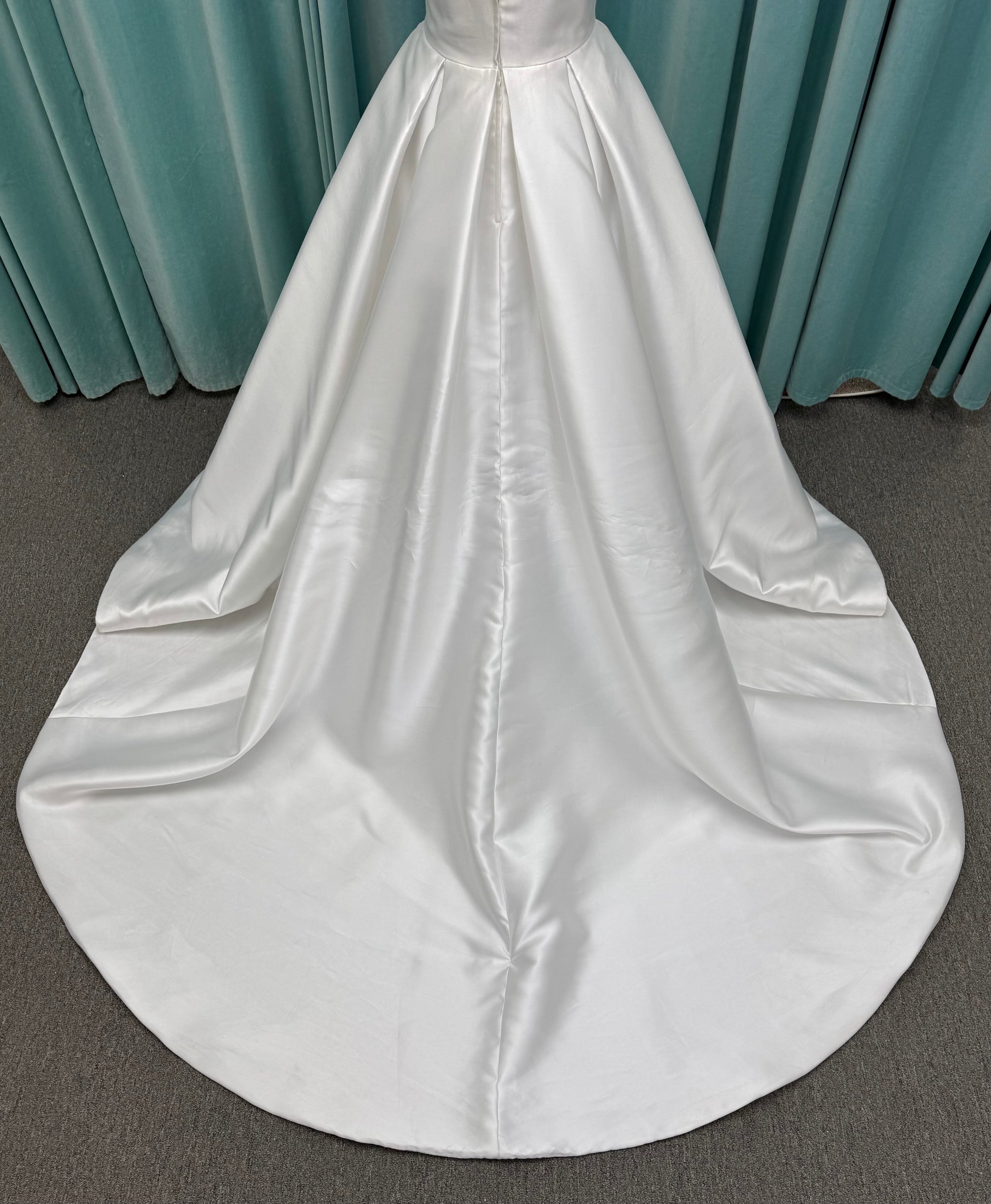 Achelios ivory strapless sweetheart satin ballgown wedding dress on mannequin with full skirt and clean structured bodice.
