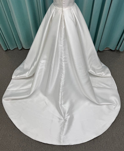 Achelios ivory strapless sweetheart satin ballgown wedding dress on mannequin with full skirt and clean structured bodice.
