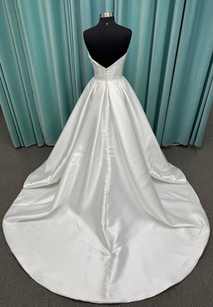 Achelios ivory strapless sweetheart satin ballgown wedding dress on mannequin with full skirt and clean structured bodice.
