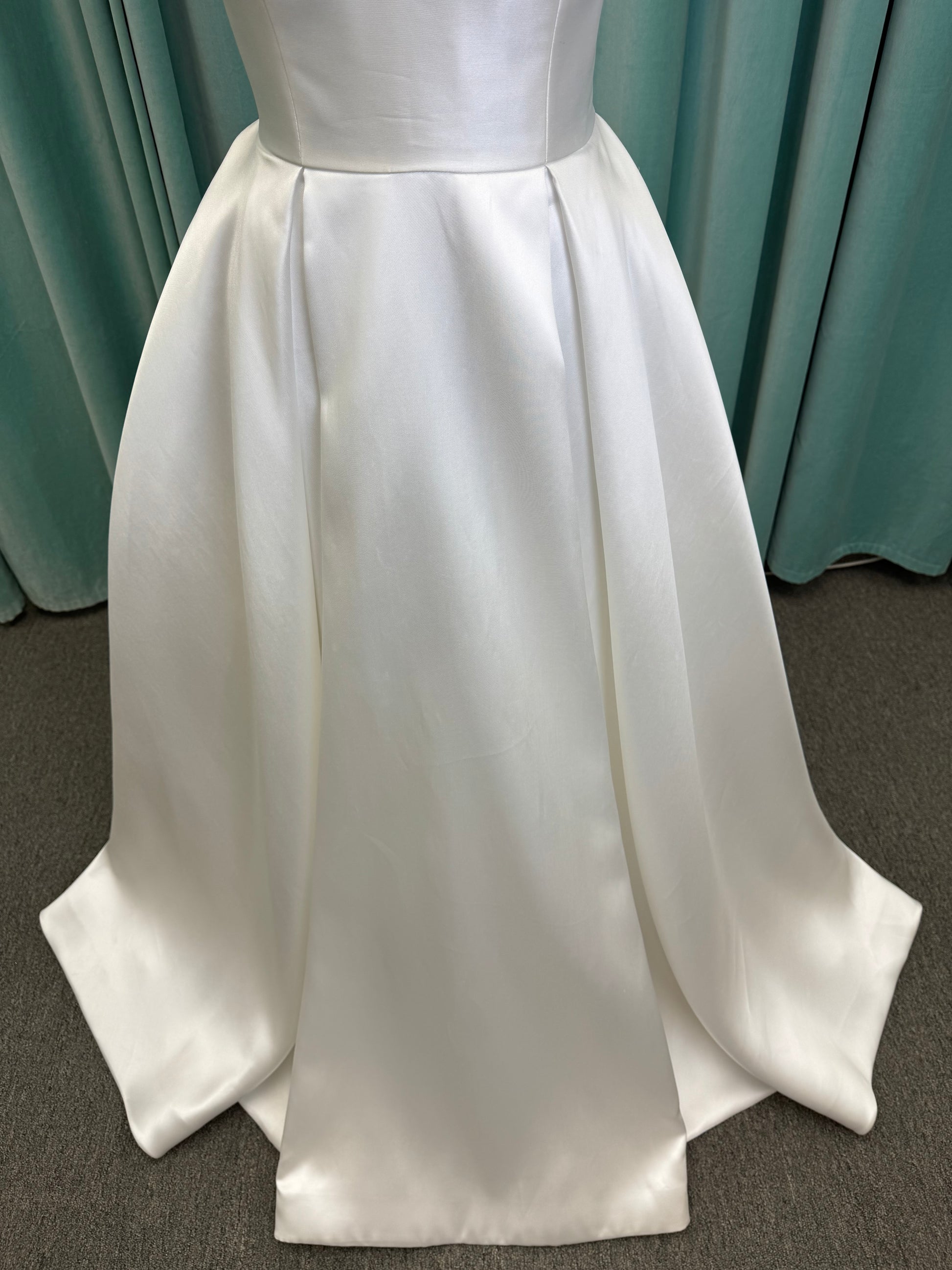 Achelios ivory strapless sweetheart satin ballgown wedding dress on mannequin with full skirt and clean structured bodice.
