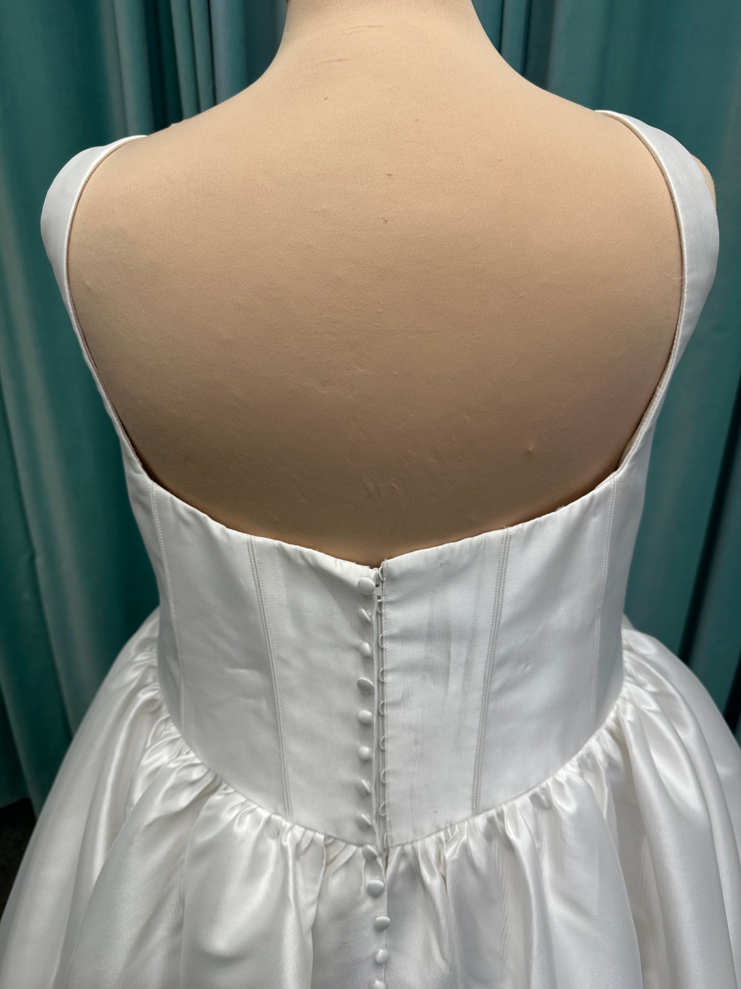 Essense of Australia D4145 ivory Mikado ballgown wedding dress on mannequin with strapless square neckline, basque waistline, and voluminous pleated skirt.
