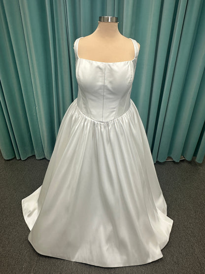 Essense of Australia D4145 ivory Mikado ballgown wedding dress on mannequin with strapless square neckline, basque waistline, and voluminous pleated skirt.
