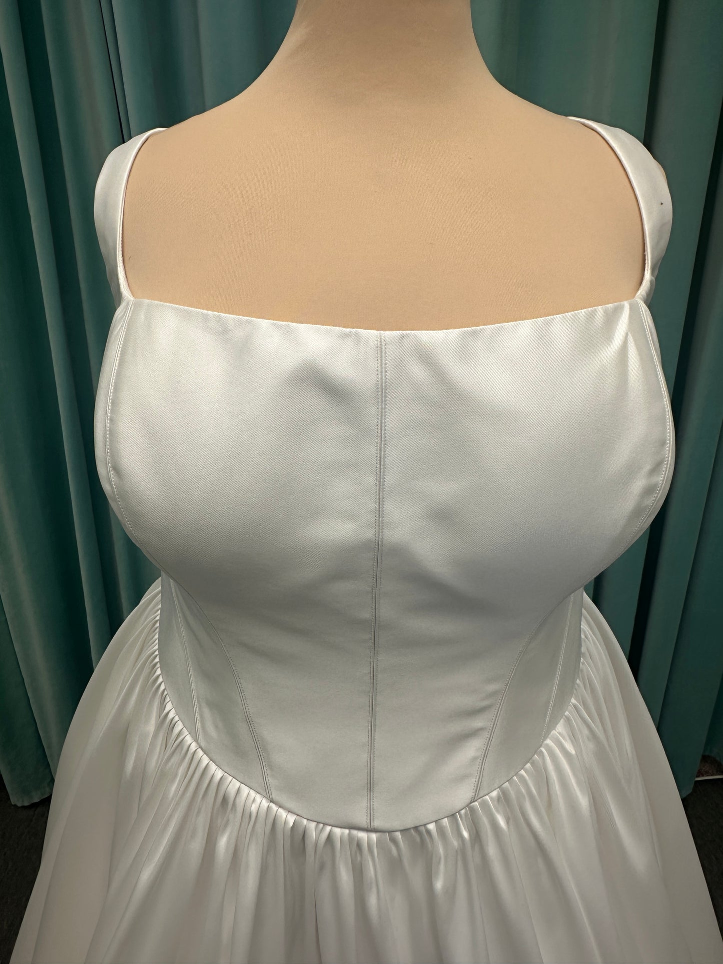 Essense of Australia D4145 ivory Mikado ballgown wedding dress on mannequin with strapless square neckline, basque waistline, and voluminous pleated skirt.
