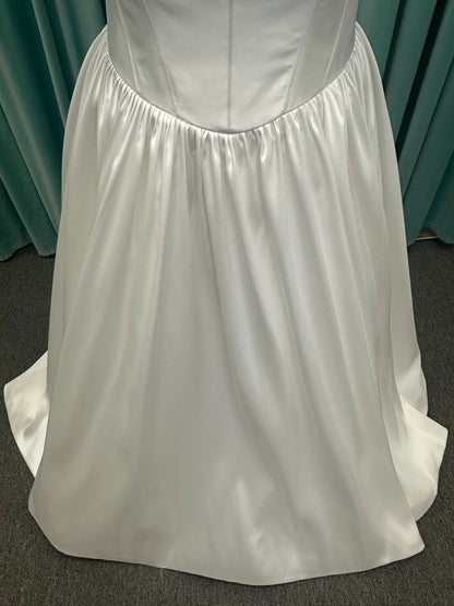 Essense of Australia D4145 ivory Mikado ballgown wedding dress on mannequin with strapless square neckline, basque waistline, and voluminous pleated skirt.
