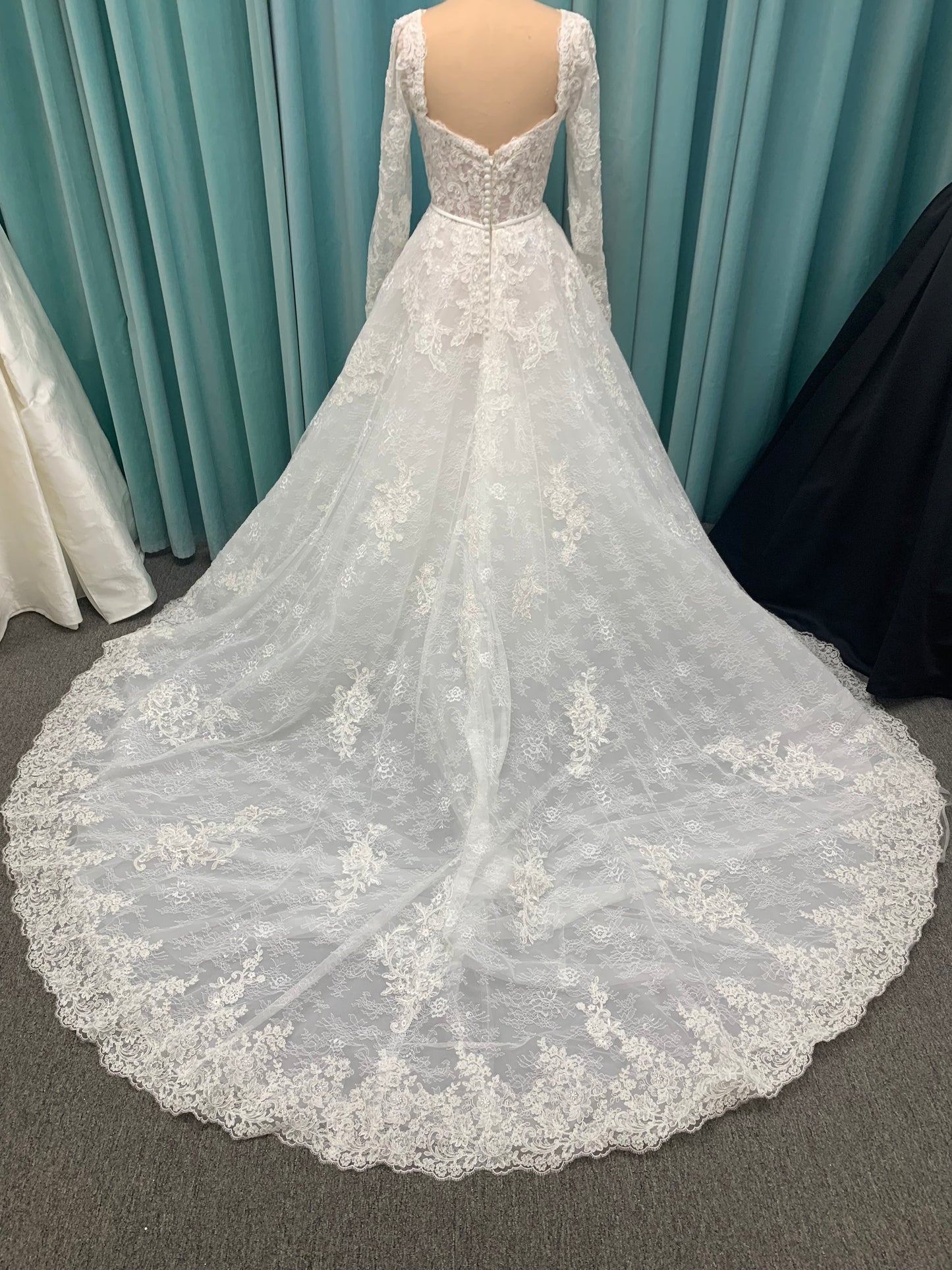 Morilee Sannah 2750 ball gown with strapless sweetheart neckline, lace corset bodice, satin bow waistband, and full tulle skirt with scalloped hem and long sleeves