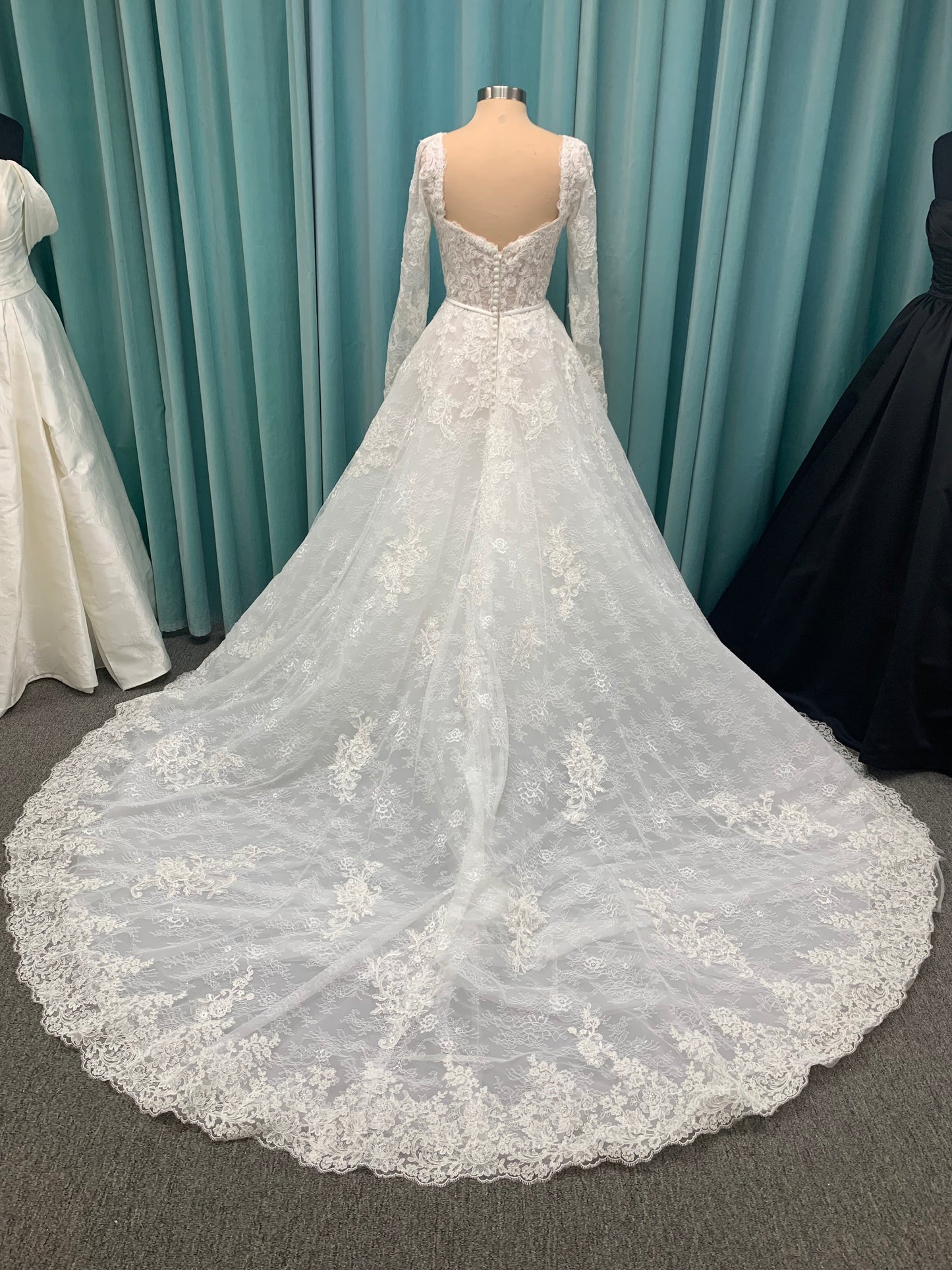 Morilee Sannah 2750 ball gown with strapless sweetheart neckline, lace corset bodice, satin bow waistband, and full tulle skirt with scalloped hem and long sleeves