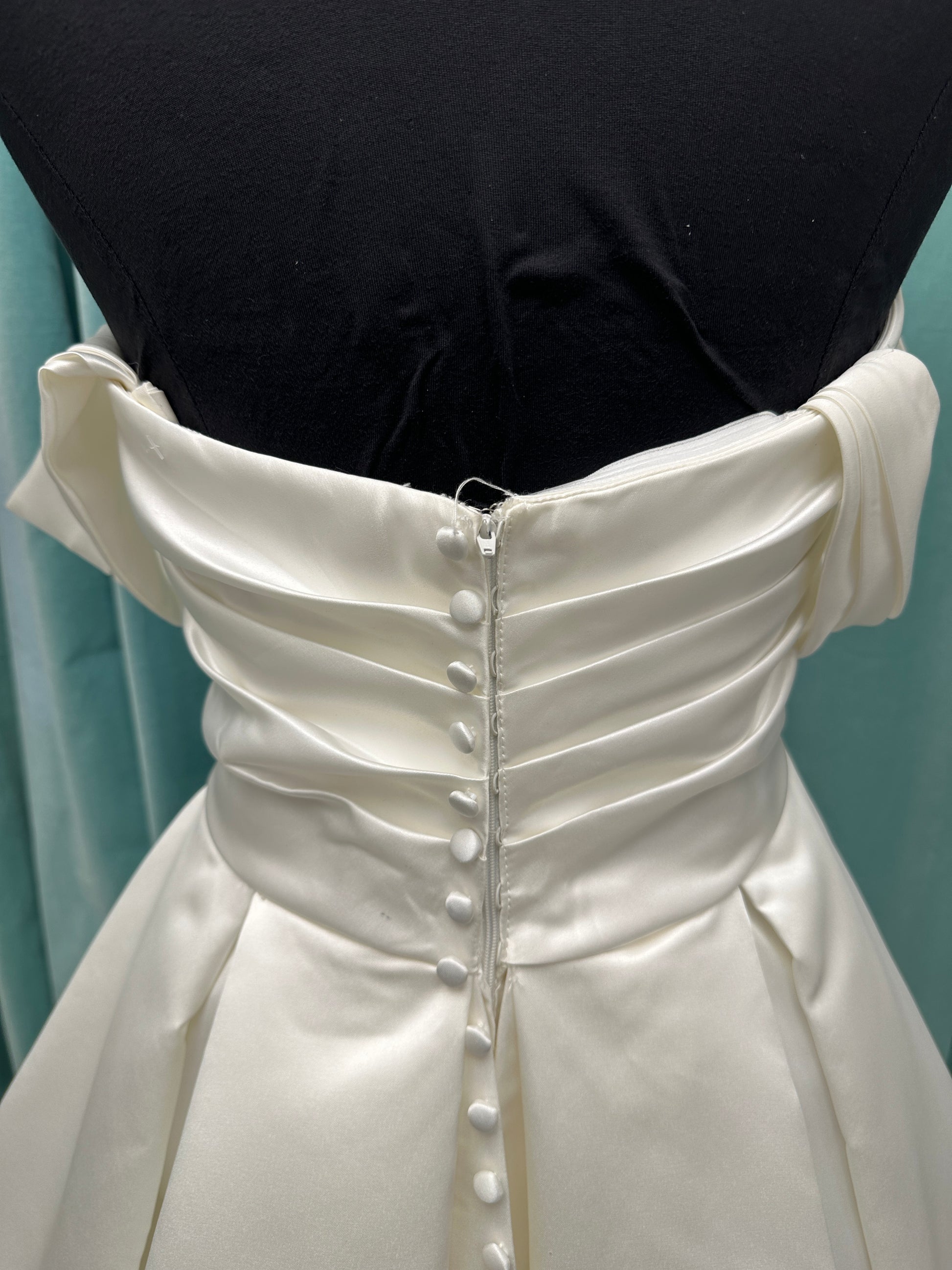 Off-the-shoulder satin A-line wedding dress with detachable straps, leg slit, pockets, and embroidered floral detailing by Essense of Australia style D4187