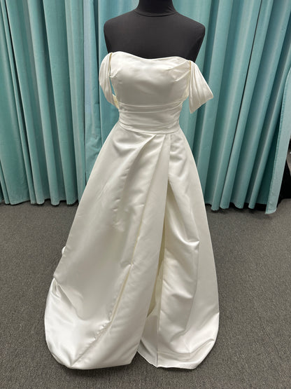 Off-the-shoulder satin A-line wedding dress with detachable straps, leg slit, pockets, and embroidered floral detailing by Essense of Australia style D4187