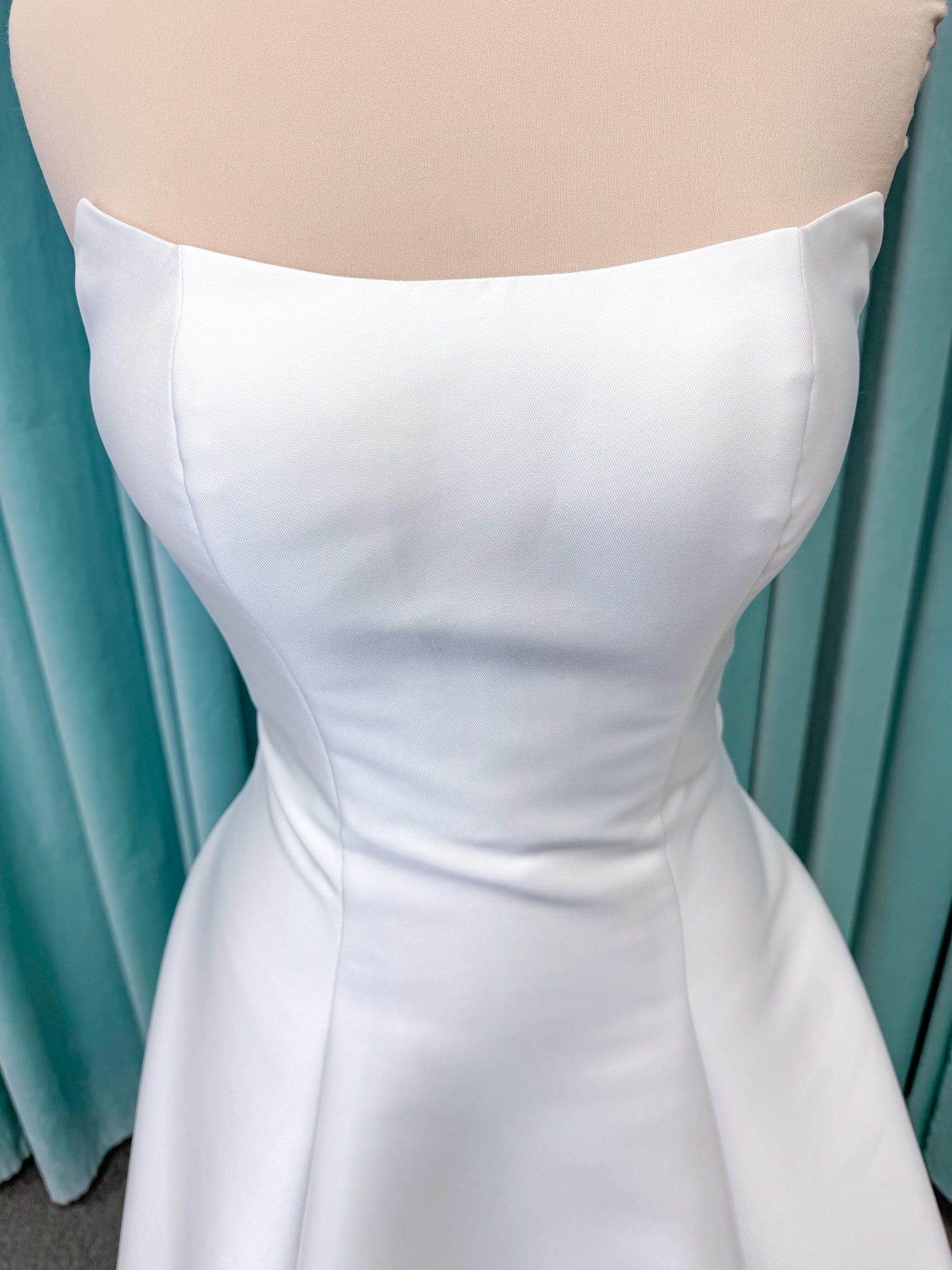 Strapless A-line wedding dress with a scoop neckline, structured drop-waist bodice, clean princess seams, and smooth full skirt.