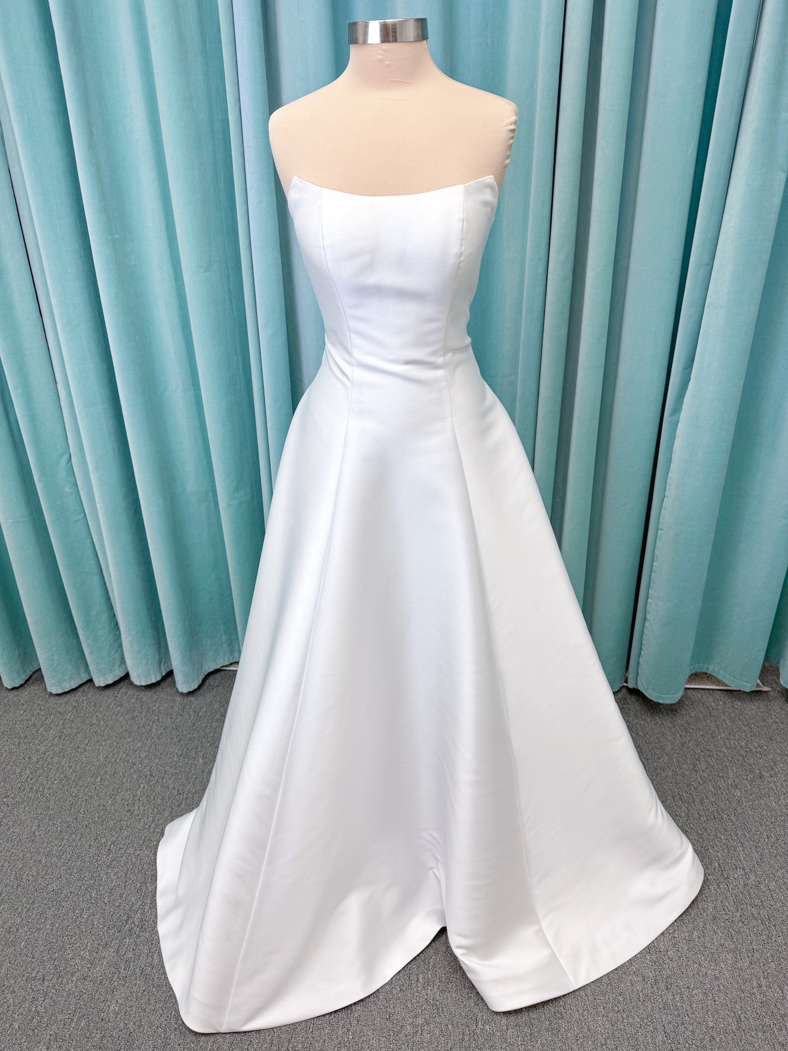 Strapless A-line wedding dress with a scoop neckline, structured drop-waist bodice, clean princess seams, and smooth full skirt.