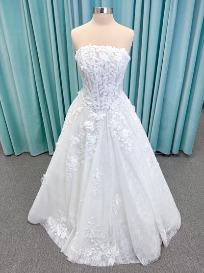Morilee 1010024 Alina A-line wedding dress on mannequin with strapless basque waist, corset boning, Chantilly lace, and hand-cut taffeta flowers