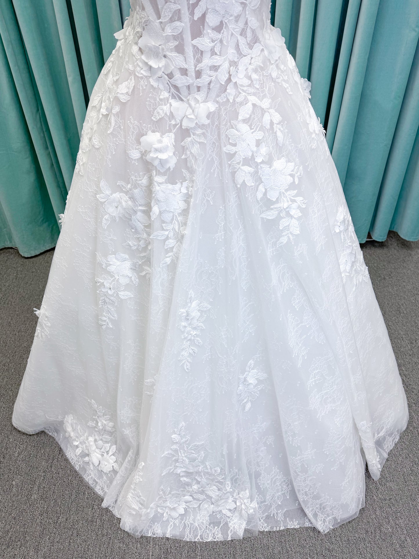 Morilee 1010024 Alina A-line wedding dress on mannequin with strapless basque waist, corset boning, Chantilly lace, and hand-cut taffeta flowers