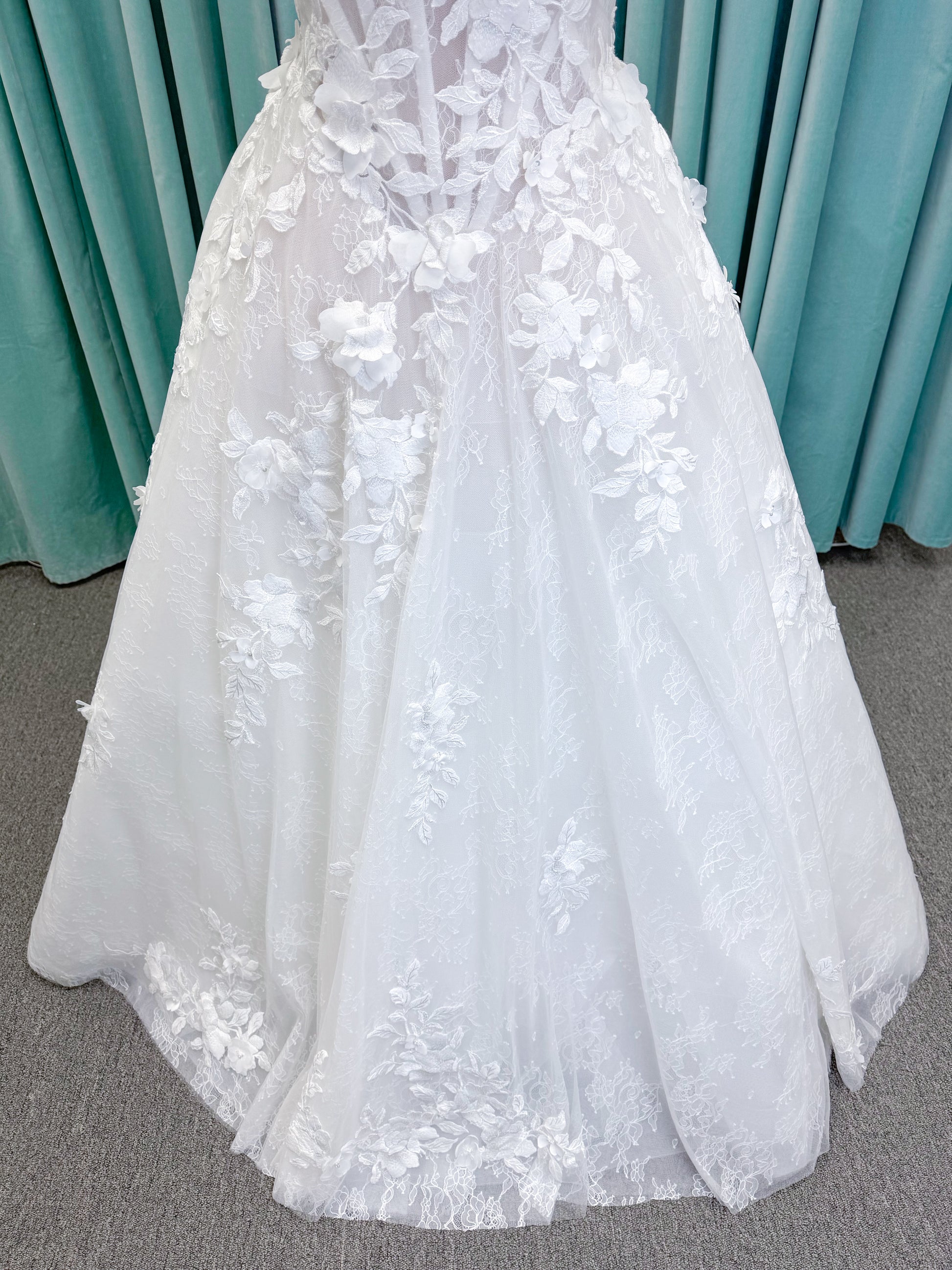 Morilee 1010024 Alina A-line wedding dress on mannequin with strapless basque waist, corset boning, Chantilly lace, and hand-cut taffeta flowers