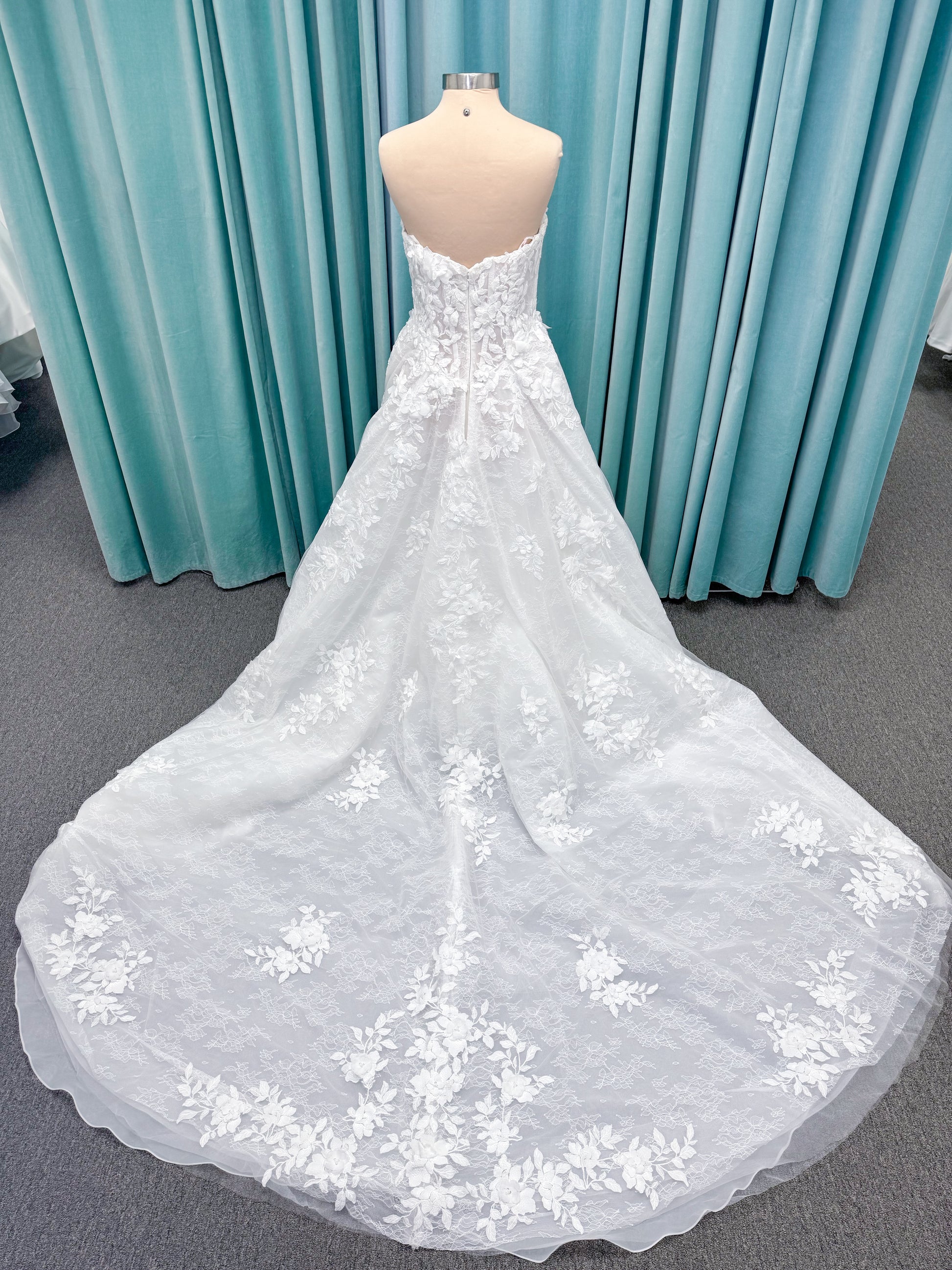 Morilee 1010024 Alina A-line wedding dress on mannequin with strapless basque waist, corset boning, Chantilly lace, and hand-cut taffeta flowers