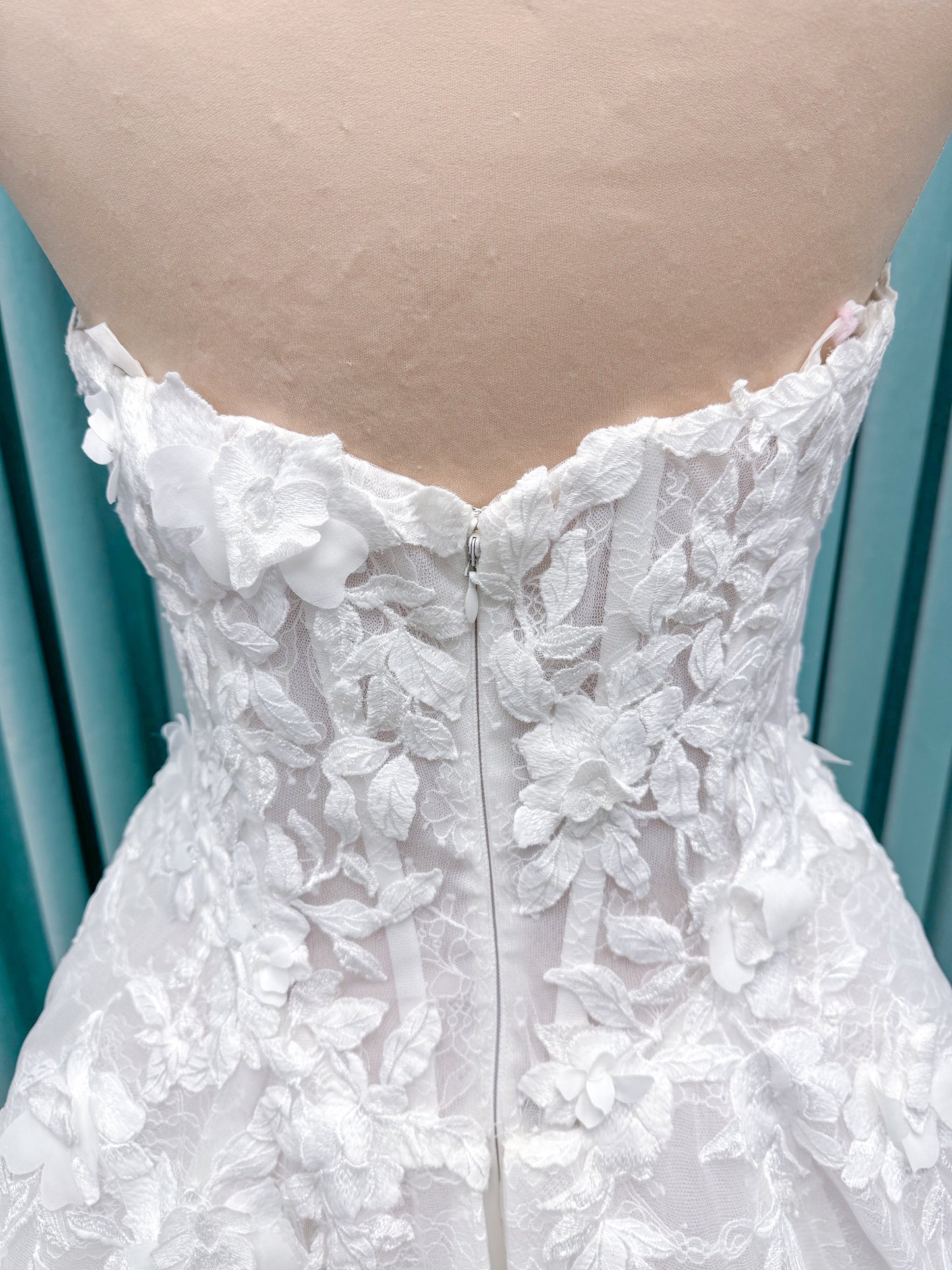 Morilee 1010024 Alina A-line wedding dress on mannequin with strapless basque waist, corset boning, Chantilly lace, and hand-cut taffeta flowers