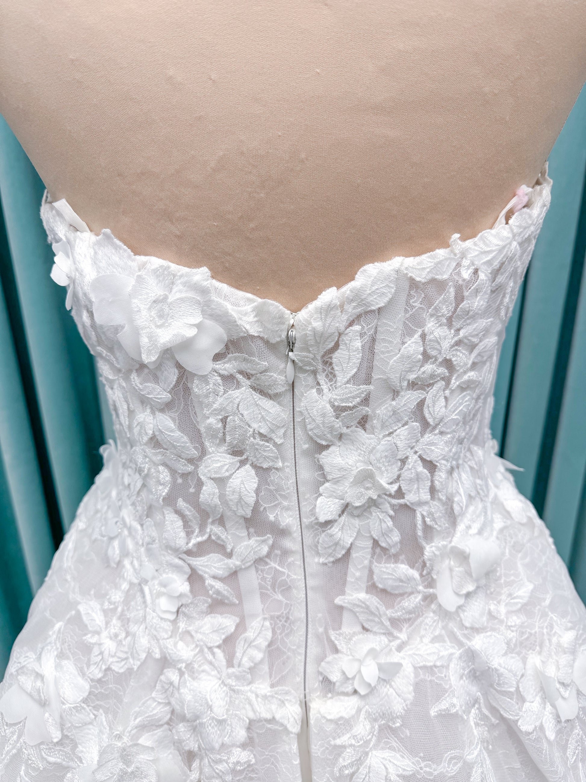 Morilee 1010024 Alina A-line wedding dress on mannequin with strapless basque waist, corset boning, Chantilly lace, and hand-cut taffeta flowers