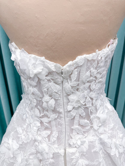 Morilee 1010024 Alina A-line wedding dress on mannequin with strapless basque waist, corset boning, Chantilly lace, and hand-cut taffeta flowers