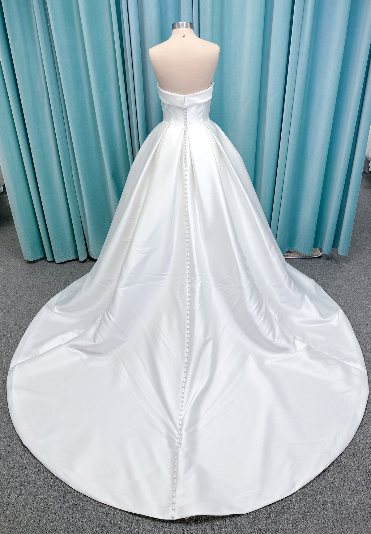 Morilee 1050011 Allegro A-line wedding dress on mannequin with strapless straight neckline, Mikado fabric, box-pleated skirt, and detachable fold-over bow