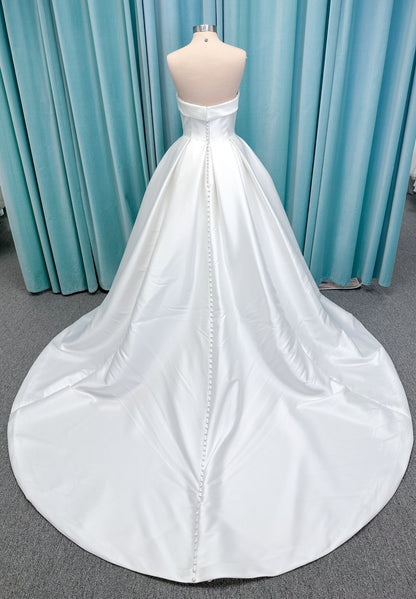 Morilee 1050011 Allegro A-line wedding dress on mannequin with strapless straight neckline, Mikado fabric, box-pleated skirt, and detachable fold-over bow