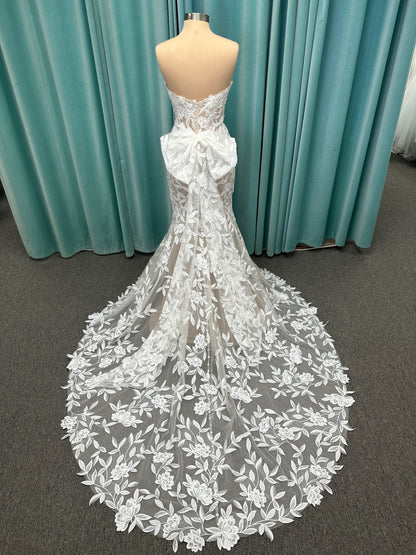 Morilee Santana wedding dress style 2739 featuring strapless sweetheart neckline, floral beaded lace, detachable long sleeves with bow streamers, and fit and flare silhouette