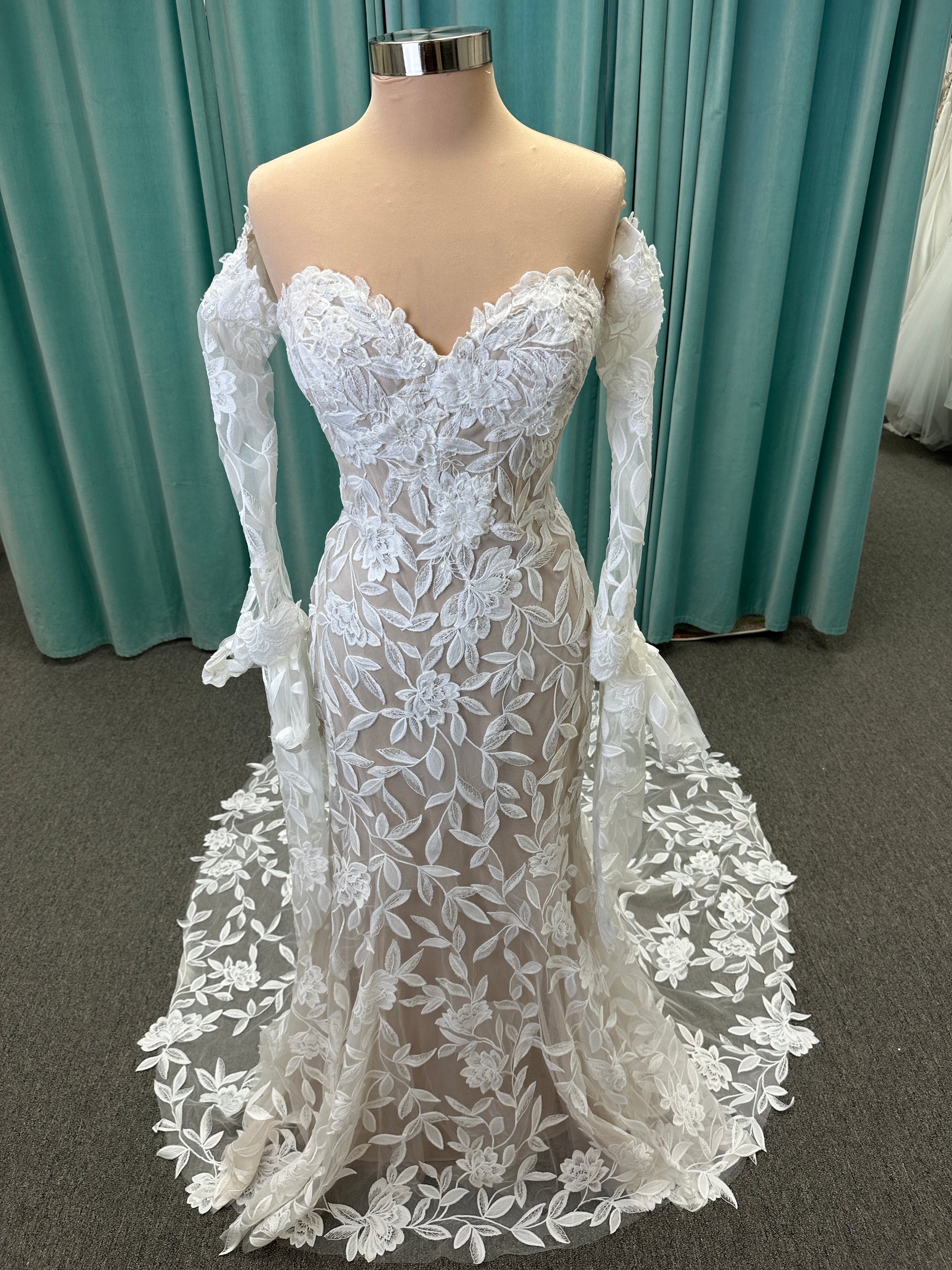 Morilee Santana wedding dress style 2739 featuring strapless sweetheart neckline, floral beaded lace, detachable long sleeves with bow streamers, and fit and flare silhouette
