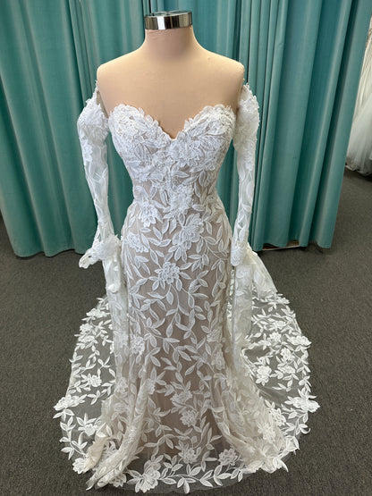 Morilee Santana wedding dress style 2739 featuring strapless sweetheart neckline, floral beaded lace, detachable long sleeves with bow streamers, and fit and flare silhouette