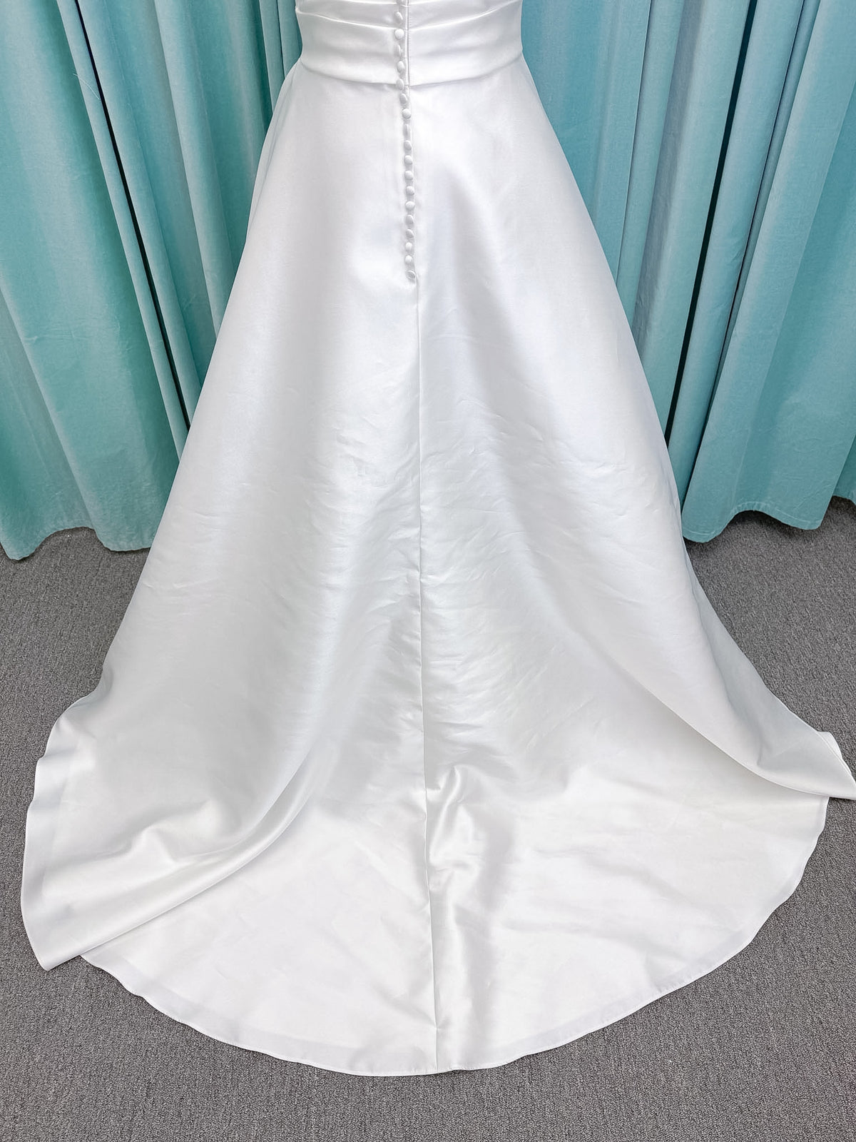 Moonlight Bridal J6852 Artemis A-line wedding dress on mannequin with strapless pointed sweetheart neckline, ruched mikado bodice, natural waist, pleated skirt with front slit, and sweep train