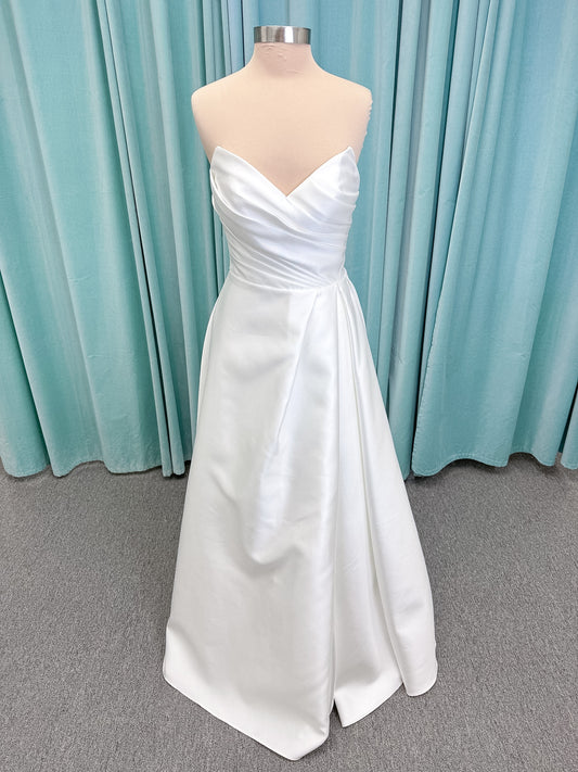 Moonlight Bridal J6852 Artemis A-line wedding dress on mannequin with strapless pointed sweetheart neckline, ruched mikado bodice, natural waist, pleated skirt with front slit, and sweep train