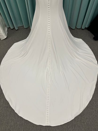 Morilee Scottie wedding dress Style 2711 with off-the-shoulder neckline, twist draped bodice, and lace-trimmed sheath skirt with slit