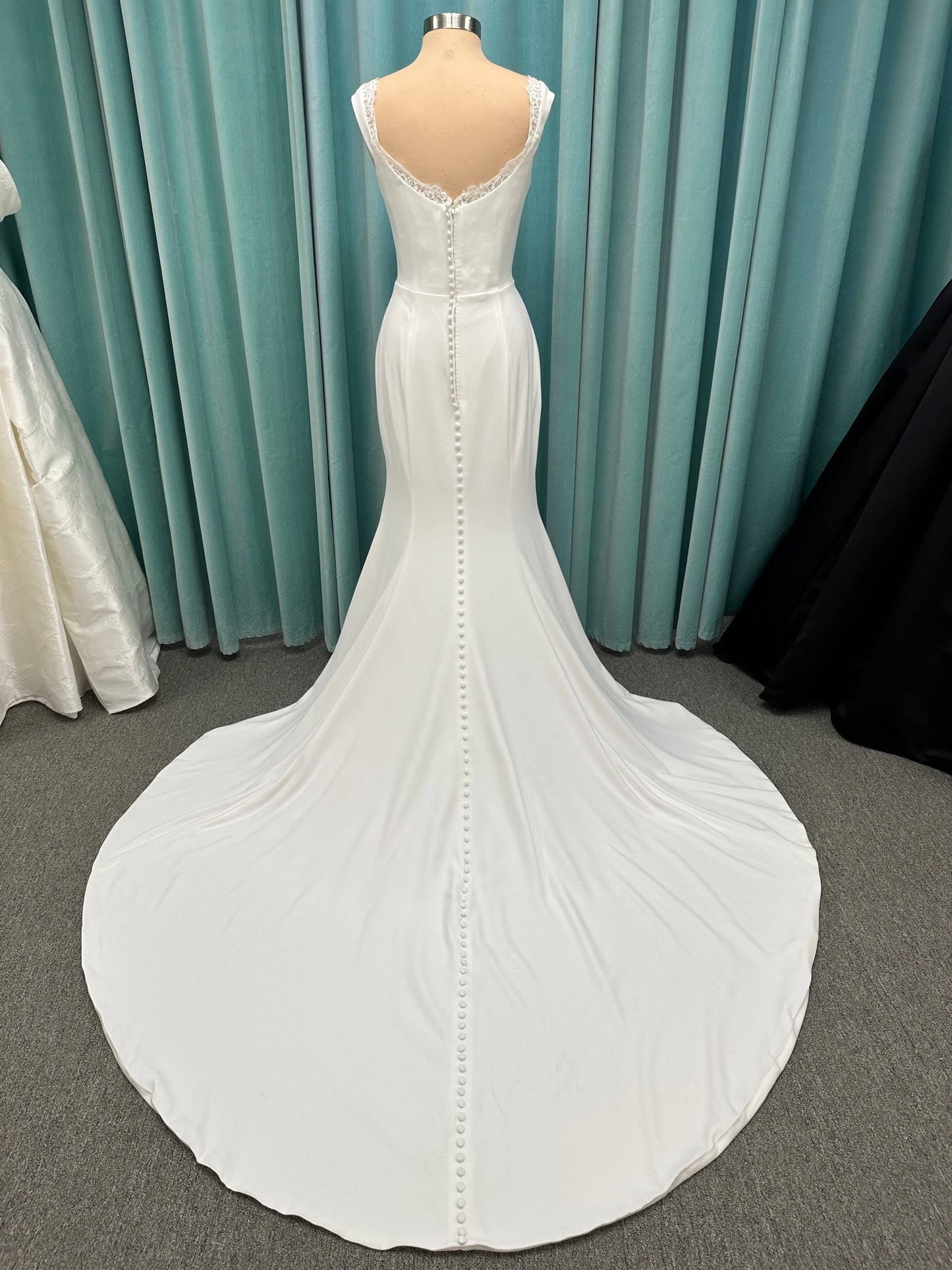 Morilee Scottie wedding dress Style 2711 with off-the-shoulder neckline, twist draped bodice, and lace-trimmed sheath skirt with slit