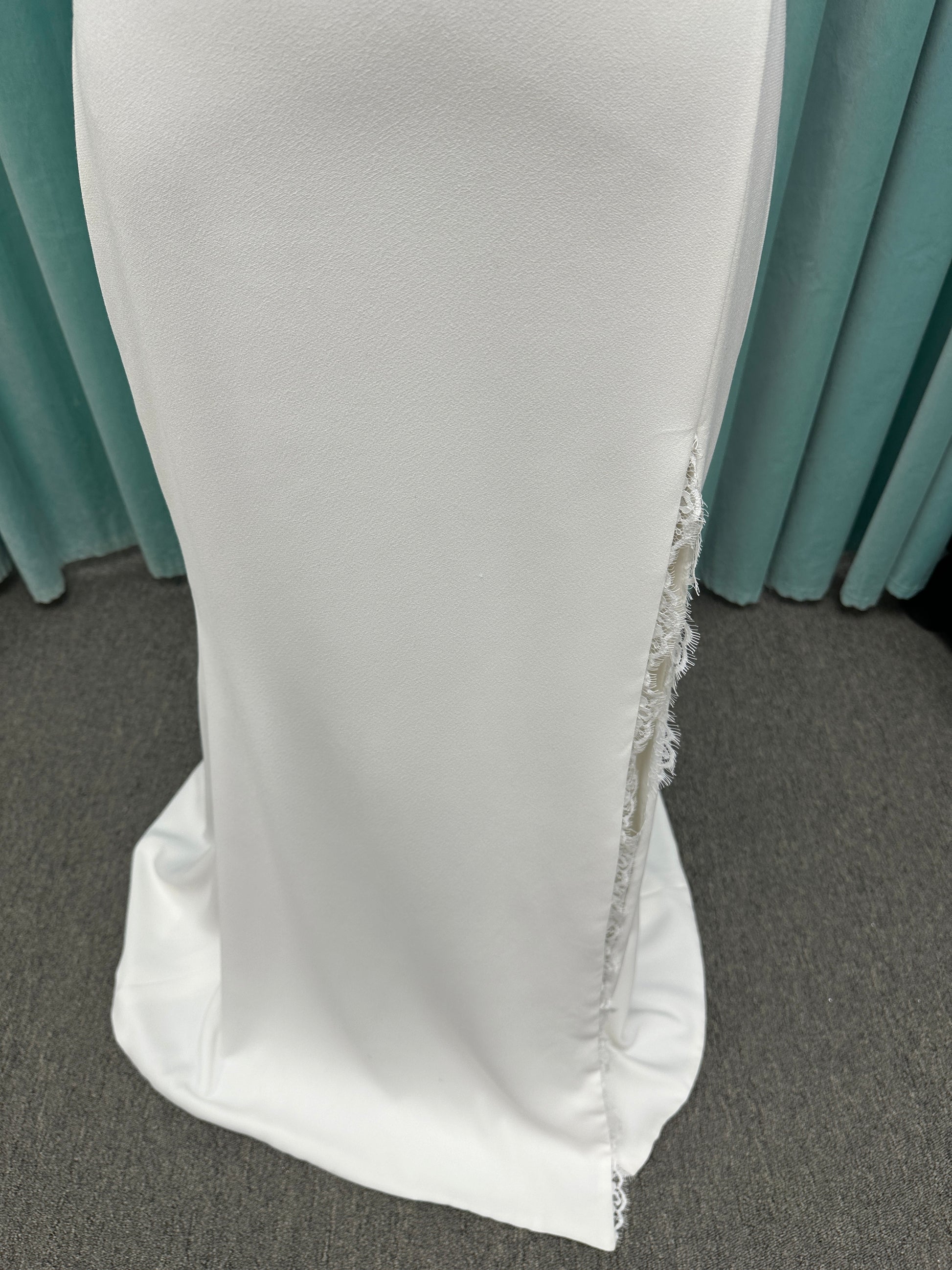 Morilee Scottie wedding dress Style 2711 with off-the-shoulder neckline, twist draped bodice, and lace-trimmed sheath skirt with slit