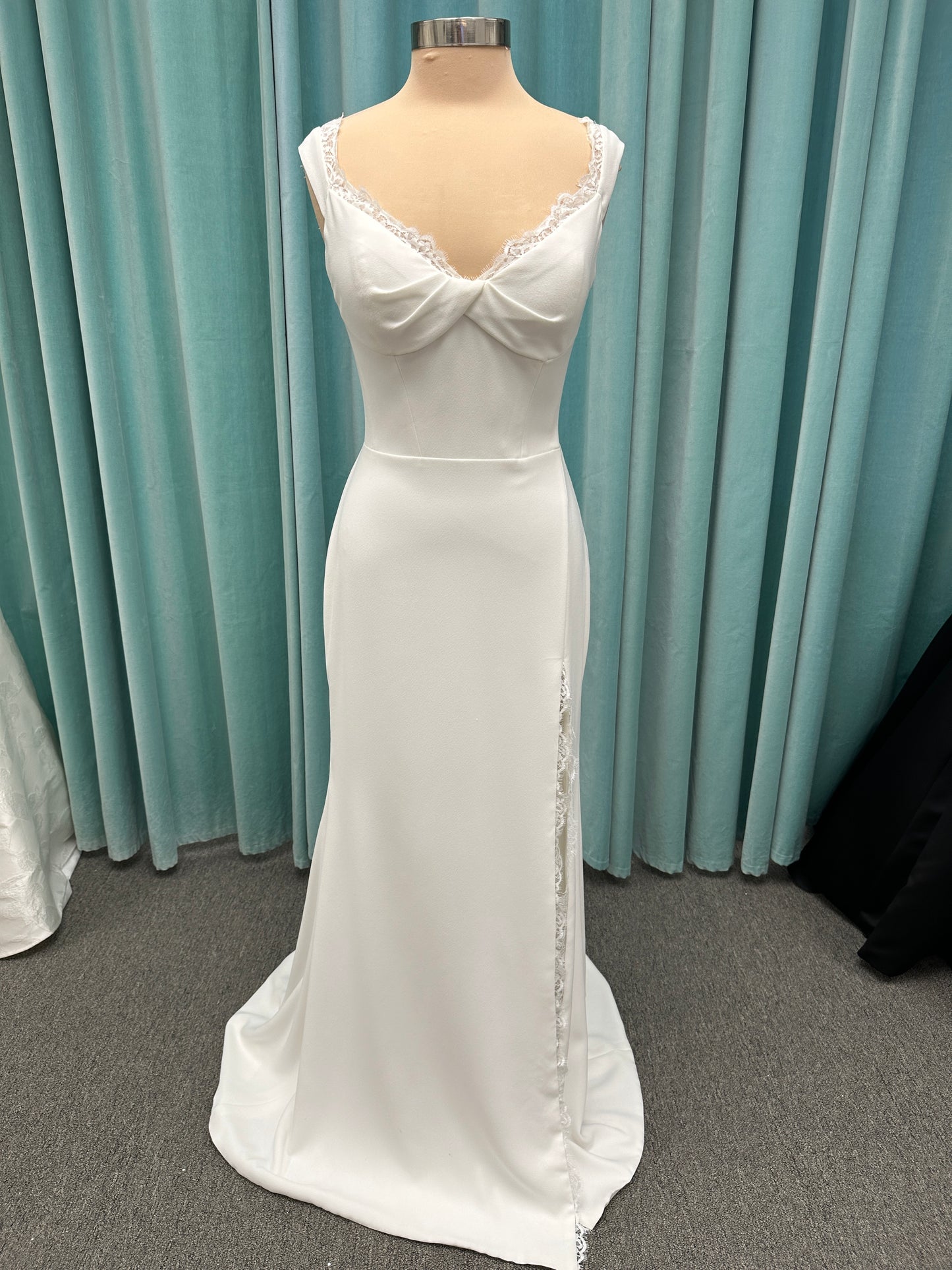 Morilee Scottie wedding dress Style 2711 with off-the-shoulder neckline, twist draped bodice, and lace-trimmed sheath skirt with slit