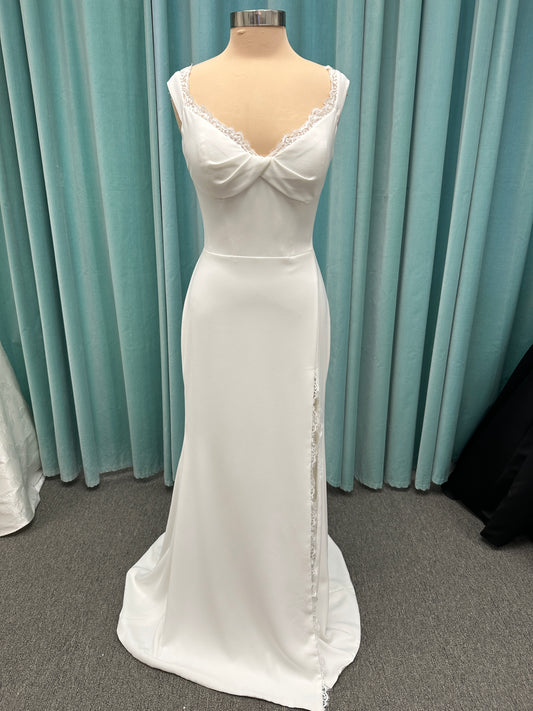 Morilee Scottie wedding dress Style 2711 with off-the-shoulder neckline, twist draped bodice, and lace-trimmed sheath skirt with slit